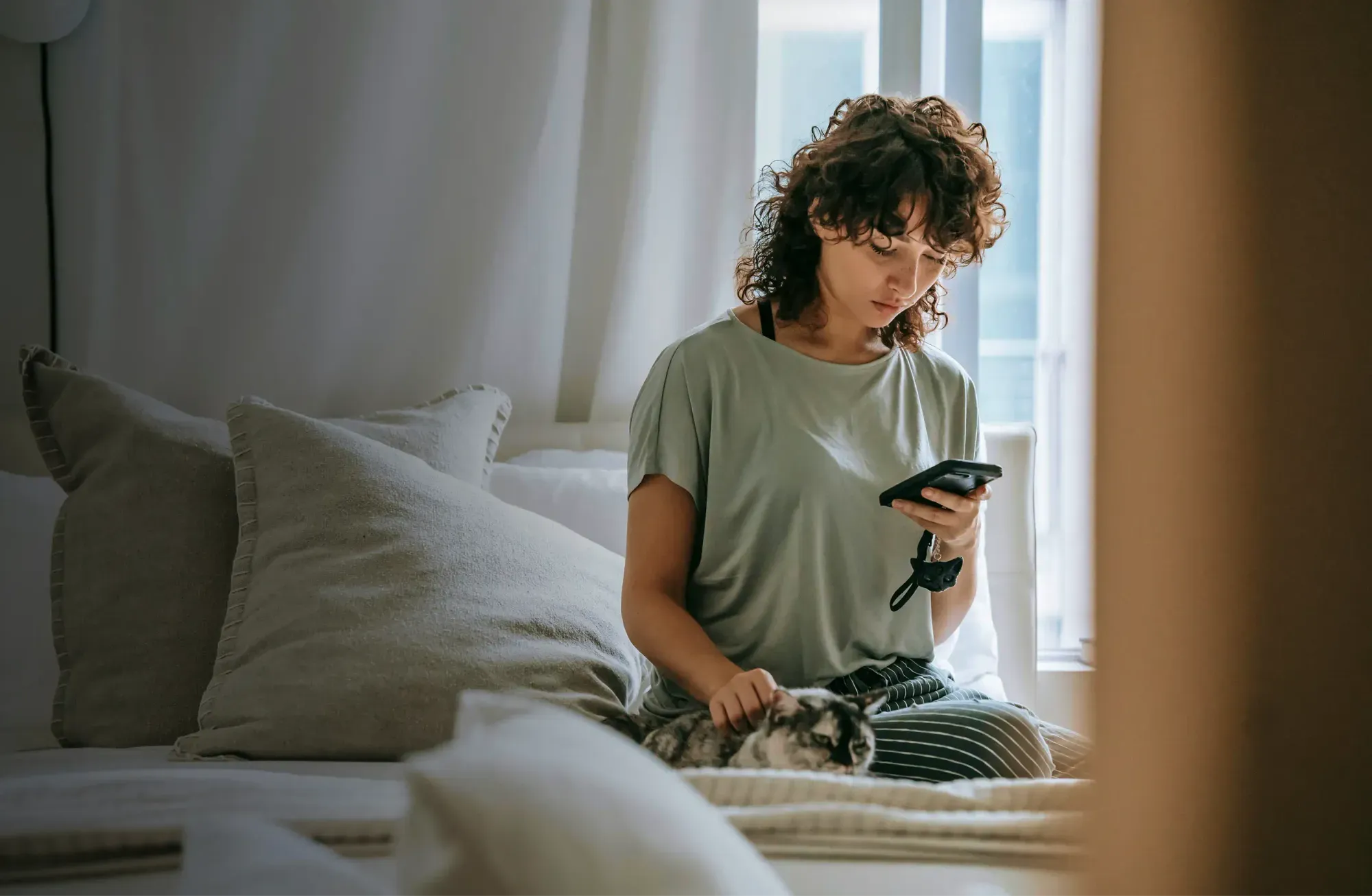 A person sitting on a bed checking their investments on the nsave app